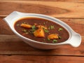 Aloo bhaji rassa, mixed tomato and potato curry, maharashtrian curry, Indian authentic food, served over a rustic wooden table,