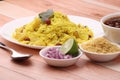 Aloo/Kanda Poha or Tarri Pohe with spicy chana masala/curry. Served in ceramic plate.