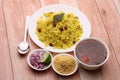 Aloo/Kanda Poha or Tarri Pohe with spicy chana masala/curry. Served in ceramic plate.