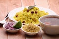 Aloo/Kanda Poha or Tarri Pohe with spicy chana masala/curry. Served in ceramic plate.