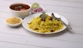 Aloo/Kanda Poha or Tarri Pohe with spicy chana masala/curry. Served in ceramic plate.