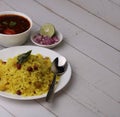 Aloo/Kanda Poha or Tarri Pohe with spicy chana masala/curry. Served in ceramic plate.