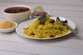 Aloo/Kanda Poha or Tarri Pohe with spicy chana masala/curry. Served in ceramic plate.