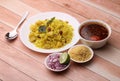 Aloo/Kanda Poha or Tarri Pohe with spicy chana masala/curry. Served in ceramic plate.