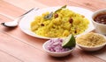 Aloo/Kanda Poha or Tarri Pohe with spicy chana masala/curry. Served in ceramic plate.