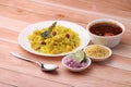 Aloo/Kanda Poha or Tarri Pohe with spicy chana masala/curry. Served in ceramic plate.