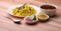 Aloo/Kanda Poha or Tarri Pohe with spicy chana masala/curry. Served in ceramic plate.