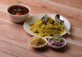 Aloo/Kanda Poha or Tarri Pohe with spicy chana masala/curry. Served in ceramic plate.