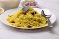 Aloo/Kanda Poha or Tarri Pohe with spicy chana masala/curry. Served in ceramic plate.