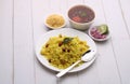 Aloo/Kanda Poha or Tarri Pohe with spicy chana masala/curry. Served in ceramic plate.