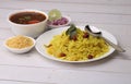Aloo/Kanda Poha or Tarri Pohe with spicy chana masala/curry. Served in ceramic plate.