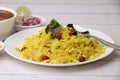 Aloo/Kanda Poha or Tarri Pohe with spicy chana masala/curry. Served in ceramic plate.