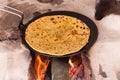 Aloo Paratha, cooking on traditinal wood fire stove chulha, top side view