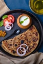 Aloo Paratha / Indian Potato Stuffed Wheat Bread served with Curd & Pickle, Tomato & Onion. North Indian or Punjabi Breakfast. Royalty Free Stock Photo