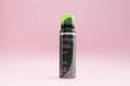 Alopel foam for hair in green metal spray bottle. Anti Hair Loss product on pink Royalty Free Stock Photo