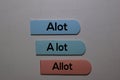 Alot, a lot, Allot write on a sticky note isolated on office desk. Learning use proper grammar Royalty Free Stock Photo