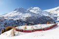 Red train from Rhaetian Railway is passing the train tracks with tight 180ÃÂ° curve