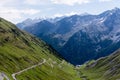 Alp road surrounded by blue alp high mountains. Steep descent of Passo dello Stelvio in Stelvio Natural Park