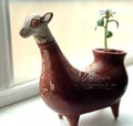 An Alpaca planter with a small plant