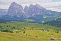 Alpe de Siusi above Ortisei with Sassolungo and Sassopiatto mountains in the background and mountain huts in the foreground, Val G Royalty Free Stock Photo