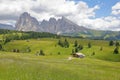 Alpe de Siusi above Ortisei with Sassolungo and Sassopiatto mountains in the background and mountain huts in the foreground, Val G Royalty Free Stock Photo
