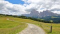 Alpe de Siusi above Ortisei with a winding path in the foreground, Sassolungo and Sassopiatto mountains in the background, Val Gar Royalty Free Stock Photo