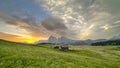 Alpe di Siusi graced by morning light, its golden hue cloaking the Dolomites