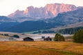 Alpe di Siusi Seiser Alm alpine meadow with beautiful sunrise in the background with the Sassolungo and Langkofel mountains Royalty Free Stock Photo