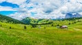Alpe di Siusi, Seiser Alm with Sassolungo Langkofel Dolomite, a close up of a lush green field in a valley canyon panorama Royalty Free Stock Photo
