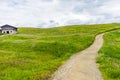 Alpe di Siusi, Seiser Alm with Sassolungo Langkofel Dolomite, a trekking walking winding path in a lush green field