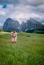 Couple men and woman on vacation in the Dolomites Italy,Alpe di Siusi - Seiser Alm with Sassolungo - Langkofel mountain