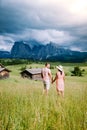 Couple men and woman on vacation in the Dolomites Italy,Alpe di Siusi - Seiser Alm with Sassolungo - Langkofel mountain