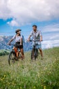 Couple men and woman on vacation in the Dolomites Italy,Alpe di Siusi - Seiser Alm with Sassolungo - Langkofel mountain Royalty Free Stock Photo