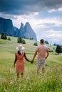 Couple men and woman on vacation in the Dolomites Italy,Alpe di Siusi - Seiser Alm with Sassolungo - Langkofel mountain Royalty Free Stock Photo