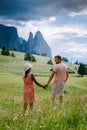 Couple men and woman on vacation in the Dolomites Italy,Alpe di Siusi - Seiser Alm with Sassolungo - Langkofel mountain Royalty Free Stock Photo