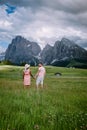 Couple men and woman on vacation in the Dolomites Italy,Alpe di Siusi - Seiser Alm with Sassolungo - Langkofel mountain Royalty Free Stock Photo