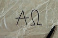 Alpha and Omega letters handwritten on crumpled paper with black marker