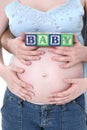 Alphabet Blocks Held By Expecting Parents Over Mom's Belly