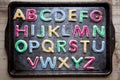 Alphabet in decorated colourful cookies on baking tray, horizontal Royalty Free Stock Photo