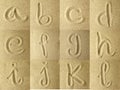 Alphabet handwritten in the sand Royalty Free Stock Photo