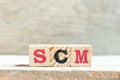 Alphabet block in word SCM Abbreviation of Supply chain management on wood background Royalty Free Stock Photo