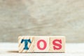 Alphabet block in word TOS abbreviation of Terms of service on wood background Royalty Free Stock Photo