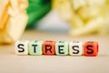 Alphabet letter dice text on desk, spelling STRESS