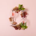 Alphabet. Letter O made of wineglasses with rose and white wine, grapes, leaves and corks lying on pink background. Wine Royalty Free Stock Photo