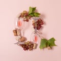 Alphabet. Letter Q made of wineglasses with rose and white wine, grapes, leaves and corks lying on pink background. Wine Royalty Free Stock Photo