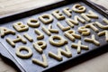 Alphabet letter shaped cookies on baking tray Royalty Free Stock Photo