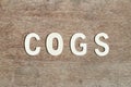 Alphabet letter in word COGS Abbreviation of Cost of goods sold on wood background