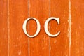 Alphabet in word OC Abbreviation of opportunity cost or original content, character on old red color wood plate