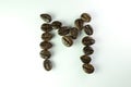 Alphabet M form Coffee beans in white background Royalty Free Stock Photo