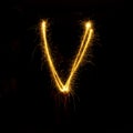 Alphabet sparklers on black background single letter